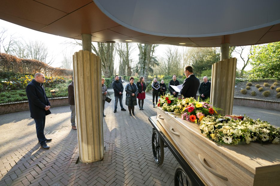 Op afstand rondom de kist vanwege coronamaatregelen