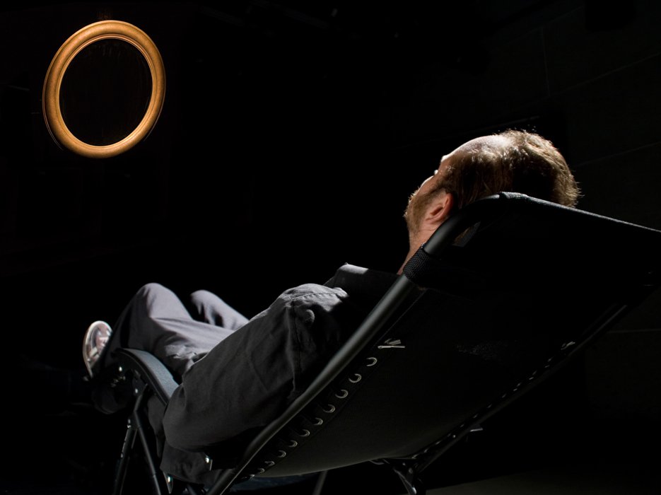 'A man sitting in a psychomanteum, a simple all black chamber with a reflective surface and a light’. Foto: courtesy Lifeafterlife/Raymondmoody
