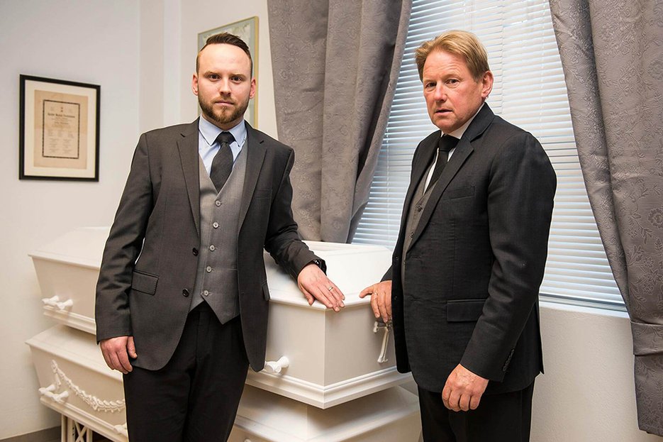 IJslandse uitvaartondernemers Rúnar Geirmundsson (r) en zijn zoon Elis Rúnarsson (l) staan rondom een traditionele witte grafkist